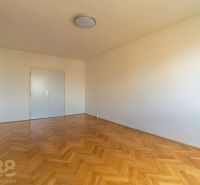 Ein Zimmer in einer 4-Zimmer-Wohnung mit weißen Wänden und einem Boden in Holzoptik.