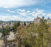 Ein Blick auf Wohnhäuser, umgeben von Grünflächen und der Straße Partizánska in Poprad.