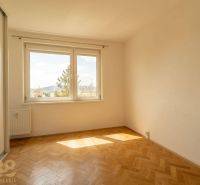 Helles Zimmer mit großen Fenstern und Holzboden in einer 4-Zimmer-Wohnung.