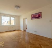 Ein geräumiges Zimmer mit einem großen Fenster, einem Boden in Holzoptik und einem Bild in einer 4-Zimmer-Wohnung.