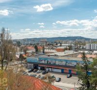 Blick auf Poprad von der Partizánska-Straße zeigt 4-Zimmer-Wohnungen und einen überfüllten Parkplatz.