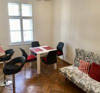 Wohnbereich in einer 2-Zimmer-Wohnung mit Holzboden und Esstisch.