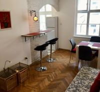Wohnzimmer mit Barhockern, Esstisch und Holzboden.