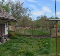 Ein Einfamilienhaus in Horné Saliby mit Rasen und Garten, umgeben von einem Zaun.