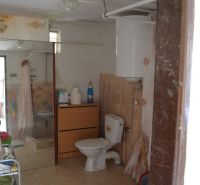Badezimmer in einem Einfamilienhaus mit Fliesen, Dusche und Toilette.