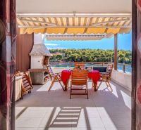 Ferienwohnung Brač mit Terrasse, Meerblick und Außenstühlen am Tisch.