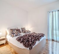 Helles Schlafzimmer mit Bett und Holzboden in der Ferienwohnung.