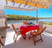 Terrasse einer Ferienwohnung in Brač mit Meerblick und Außensitzbereich.