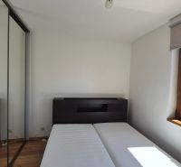 Schlafzimmer im Ferienapartment mit Holzboden und Kleiderschrank.