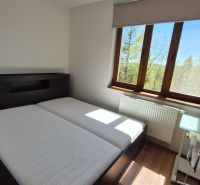 Schlafzimmer mit Doppelbett, Holzboden und Fenster im Ferienapartment.