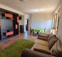 Ferienwohnung mit Holzboden, Sofa und bunter Wandgestaltung.