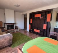 Ferienwohnung mit Holzboden, Kamin und Küchenzeile, gemütliches Interieur.