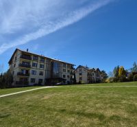 Eine Ferienwohnung in Stará Lesná in der Hohen Tatra, umgeben von Rasen und Bäumen.