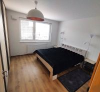 Schlafzimmer mit Doppelbett, Lampen und Holzboden in einer 2-Zimmer-Wohnung.