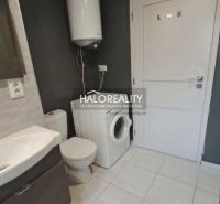 Badezimmer in einer 3-Zimmer-Wohnung mit Waschmaschine und Boiler, Fliesen in hellem Farbton.