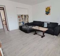 Wohnzimmer in einer 3-Zimmer-Wohnung mit Holzboden und bequemer Couch.