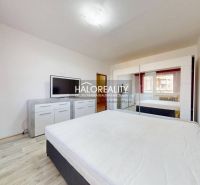 Schlafzimmer mit weißem Interieur und Holzboden in einer 2-Zimmer-Wohnung.