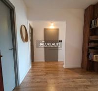 Flur in einer 3-Zimmer-Wohnung mit Holzboden und eingebautem Regal.