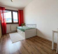Ein helles Zimmer mit einem Bett, einem Tisch und einem Holzboden in einer 3-Zimmer-Wohnung.