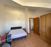 Schlafzimmer in einer Ferienwohnung mit Bett, Schrank und Fernseher.