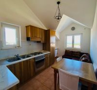 Küche mit Holzelementen, Esstisch und Sofa in einer Ferienwohnung.