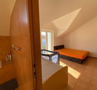 Interieur einer Ferienwohnung mit Sofa, Bett und Kinderbett.