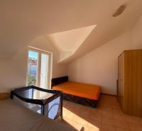 Schlafzimmer in der Ferienwohnung mit Betten, Schrank und Kinderbett.