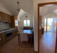 Die Küche der Ferienwohnung mit Holzschränken und Meerblick.
