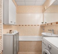 Badezimmer in einer 3-Zimmer-Wohnung mit Badewanne, Waschmaschine und Schrank.
