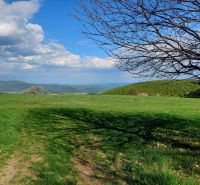 Schöne grüne Landschaft in Budiná mit Blick auf die Hügel und den blauen Himmel.