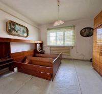 Schlafzimmer in einem Einfamilienhaus mit Holzmöbeln und Kronleuchter.