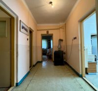 Der Flur in einem Einfamilienhaus mit einfacher Beleuchtung und älterem Innendesign.