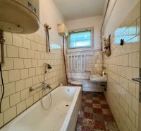 Badezimmer in einem Einfamilienhaus mit Badewanne, Waschbecken und Fliesen.