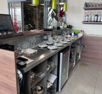 Eine Bartheke mit Getränken und Geschirr in einem Gastronomiebereich mit einem Boden in Holzoptik.