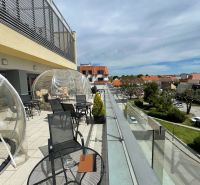 Terrasse am Dreifaltigkeitsplatz in Trnava mit Sitzgelegenheiten in Gastronomiebereichen.