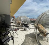 Terrasse in Trnava auf dem Dreifaltigkeitsplatz mit Gastronomiebereichen und durchsichtigen Kuppeln.