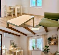 Wohnzimmer mit Holzdecke und Boden in Holzoptik in einem Einfamilienhaus.
