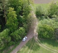 Ein Auto auf einem Waldweg zwischen grüner Vegetation in den Erholungsgebieten in Streženice.