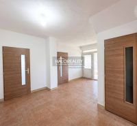 Innenraum eines Einfamilienhauses mit Keramikboden und Holztüren.