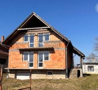 Ein Einfamilienhaus in Radvaň nad Dunajom mit unvollendeter Fassade und großen Fenstern.