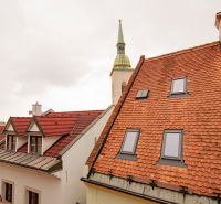 Der Kirchturm, der über die Dächer in der Beblavého Straße in Bratislava hinausragt.