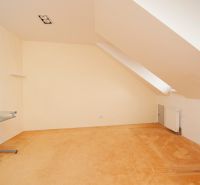 Dachzimmer mit Schreibtisch und Heizkörper in einer 3-Zimmer-Wohnung.