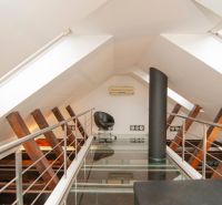 Dachbodenraum mit Glasboden, Sessel und Klimaanlage in einer 3-Zimmer-Wohnung.