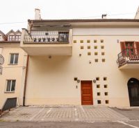 Fassade des Gebäudes mit Balkonen und Parkplatz vor dem Eingang.