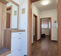 Geräumiger Flur mit Möbeln und Holzboden in einem Einfamilienhaus.