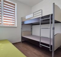 Etagenbett und grünes Sofa in einem Einfamilienhaus mit Holzboden.