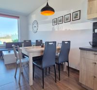Esszimmer in einem Einfamilienhaus mit Holzboden und großem Fenster.