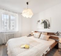 Helles Schlafzimmer mit einem Holzbett, einem Bild an der Wand und einem Boden mit Holzdekor.