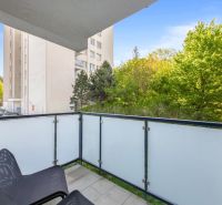 Balkon einer 2-Zimmer-Wohnung in Bratislava - Altstadt mit Blick auf Grünflächen und ein Gebäude.