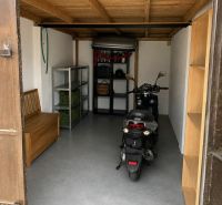 Garagen mit Motorrad, Holzdecke und Regalen zur Lagerung.